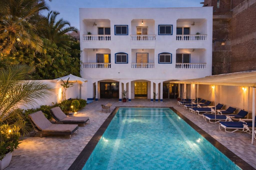 a hotel with a swimming pool in front of a building at Ali Baba Hotel in Luxor