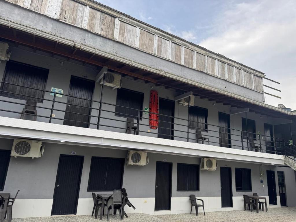 a building with a balcony with tables and chairs at Los Cabos in Bahía Solano