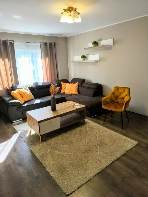 a living room with a couch and a coffee table at L&H Apartment in Odorheiu Secuiesc