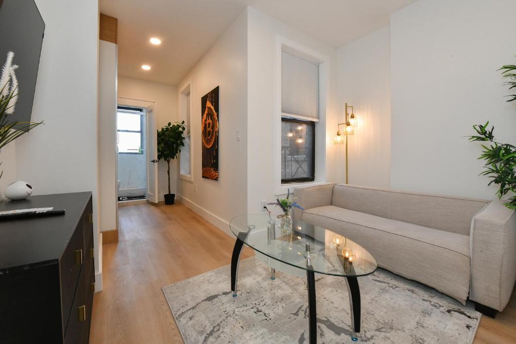 a living room with a couch and a glass table at Chic 2BR Stay-Steps From Central Park in New York