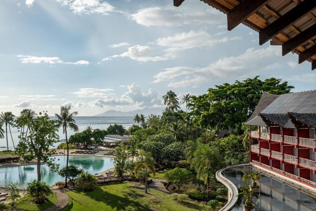 a view of the pool and ocean from the balcony of a resort at Tahiti Lagoon Resort in Punaauia
