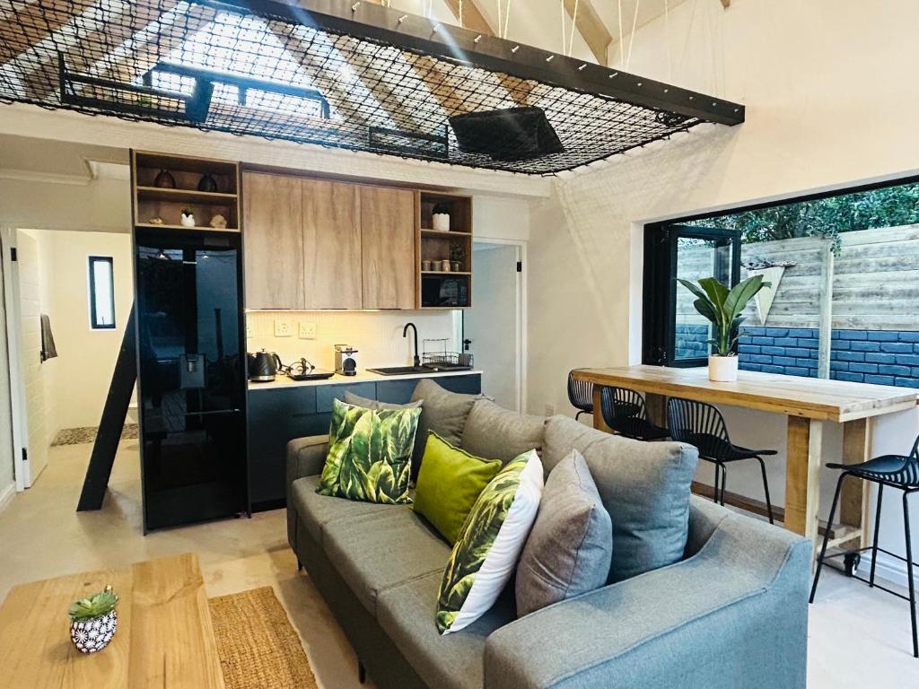 a living room with a couch and a kitchen at Ocean Whisper Beach Villas in Jeffreys Bay