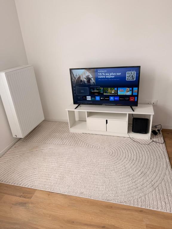a flat screen tv sitting on top of a white entertainment center at Bright and cozy studio entre Paris et Disneyland in Champs-sur-Marne