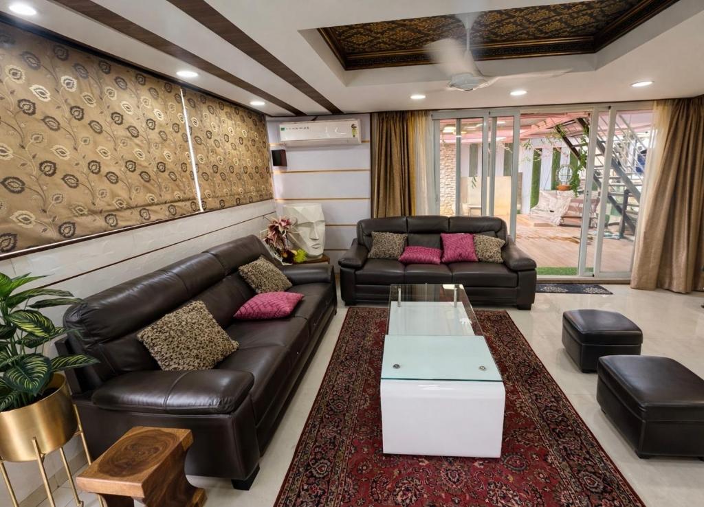 a living room with leather couches and a coffee table at Shri krishna paradise in Panvel