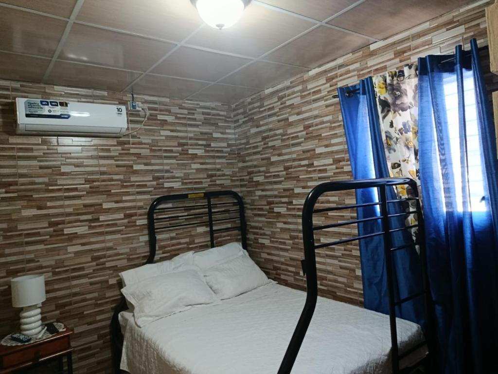 a small bedroom with a bed and a window at Apartamento de July in Penonomé
