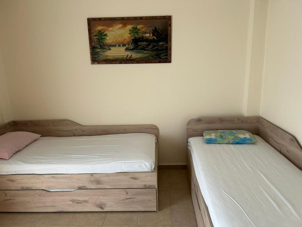 two beds in a room with a picture on the wall at petite apartment in Asprovalta