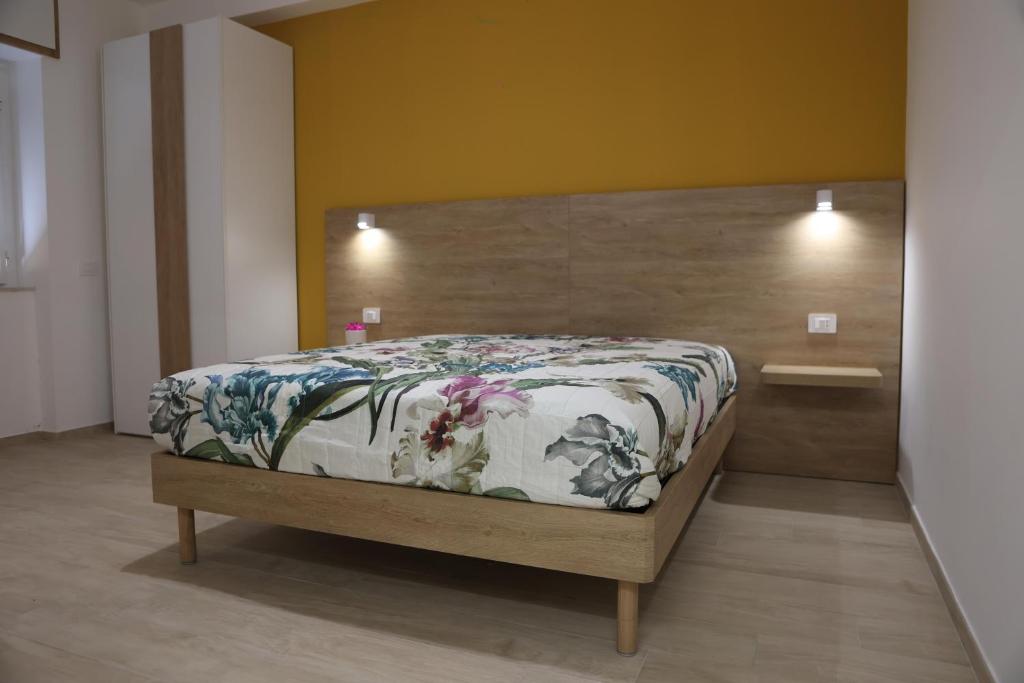 a bedroom with a large bed with a wooden headboard at B&B Le Eolie in Milazzo