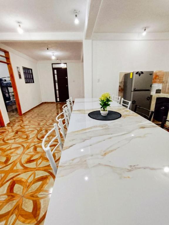 a long table with white chairs and a vase of flowers at Casa Los Reyes in La Magdalena Atlipac