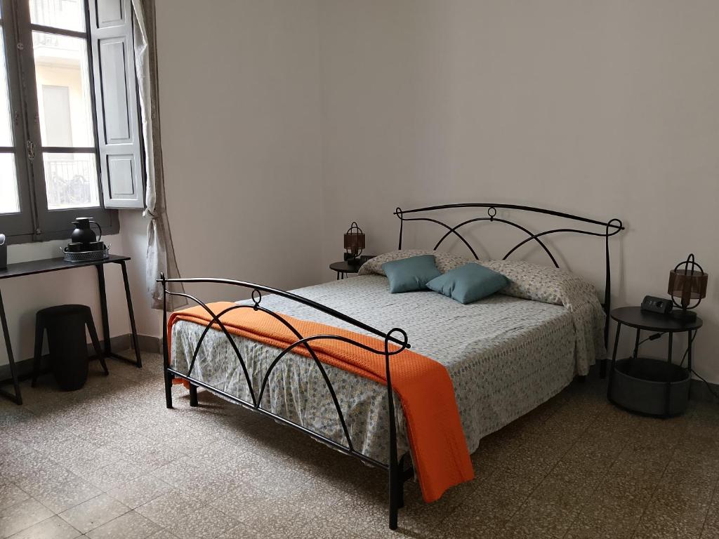a bedroom with a bed with an orange blanket at CASTEDDU rooms in Cagliari