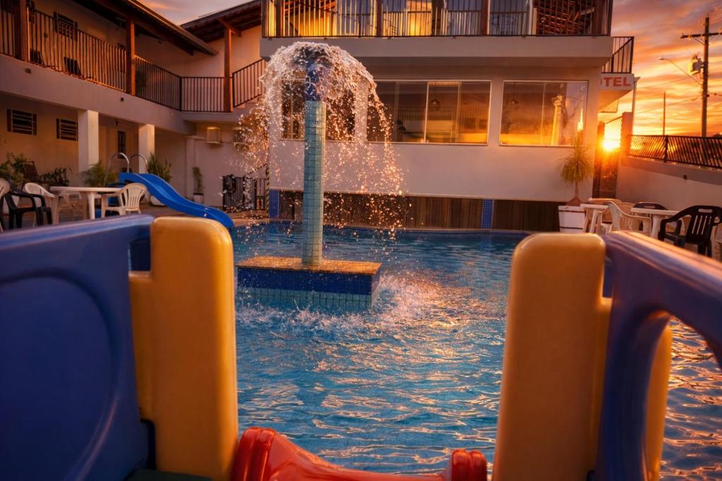 a water slide in a pool with a fountain at Hotel Picadão in São Pedro