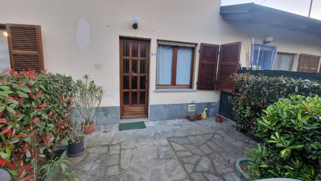 a house with a wooden door and some plants at Casa Del Cuore in Torre Pellice