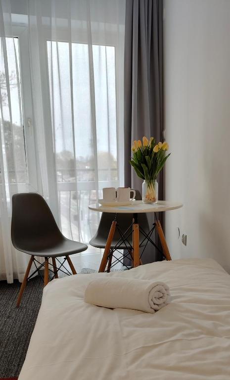 a bedroom with a bed and a table and a chair at Noclegi Flauta in Mielno