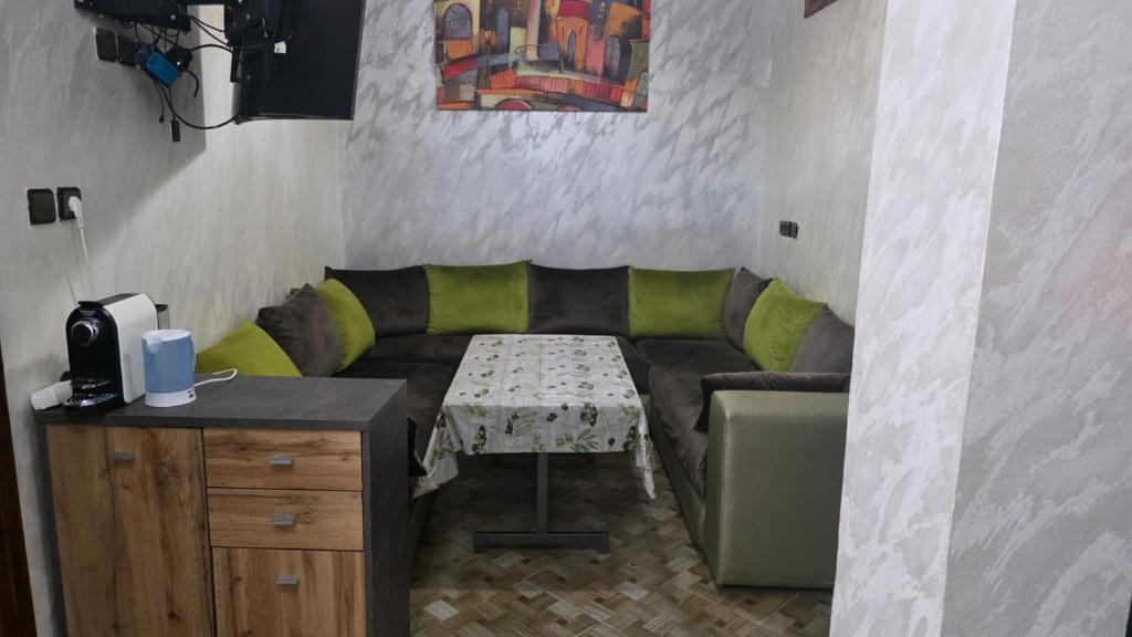 a living room with a couch and a table at Maison marhaba2 app2 in Inezgane