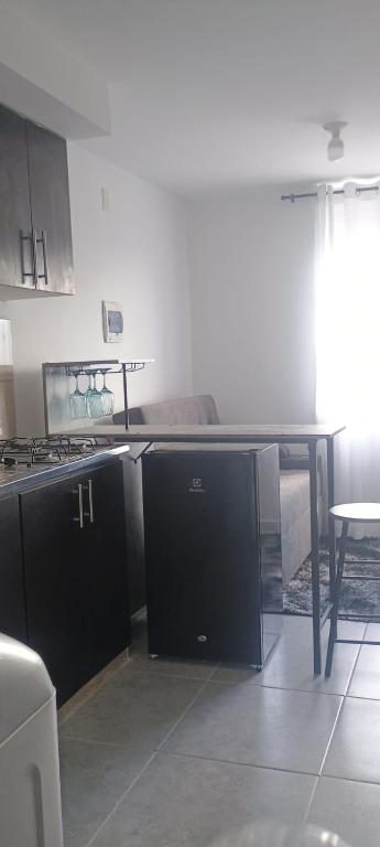a kitchen with a stove and a table in a room at Ensueño 904 in Armenia