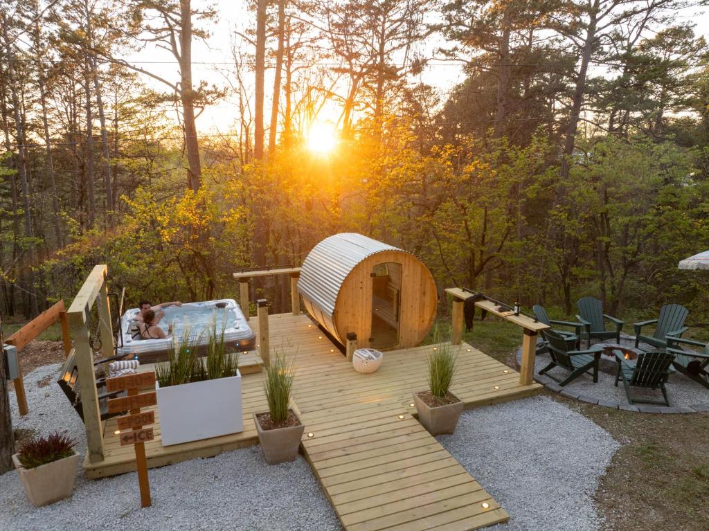 a wooden deck with a hot tub and a yurt at The Woodsman Lodge in Eureka Springs