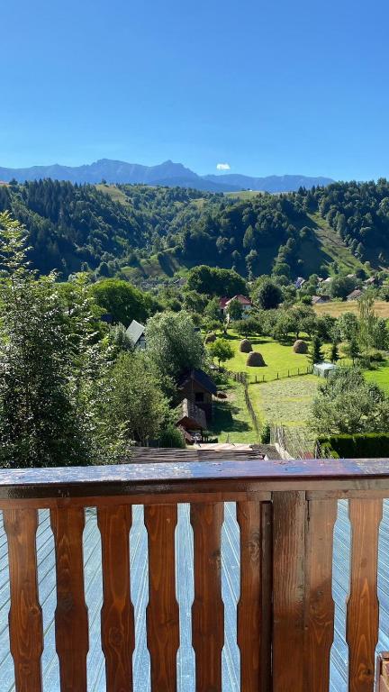 a wooden balcony with a view of a valley at Pensiunea Brian in Moieciu de Jos