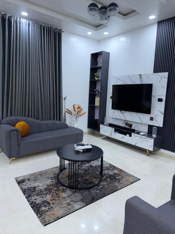 a living room with a couch and a tv at LUXURY 4BR Duplex with STARLINK ,PS5 and 247 power 4mins to GRA in Port Harcourt
