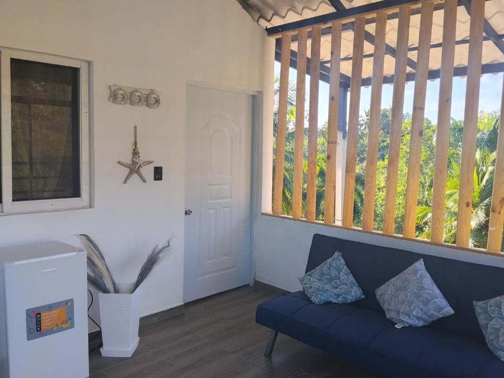 a living room with a blue couch and a window at Residence Xamanai Playa Rincón II in Palmarito