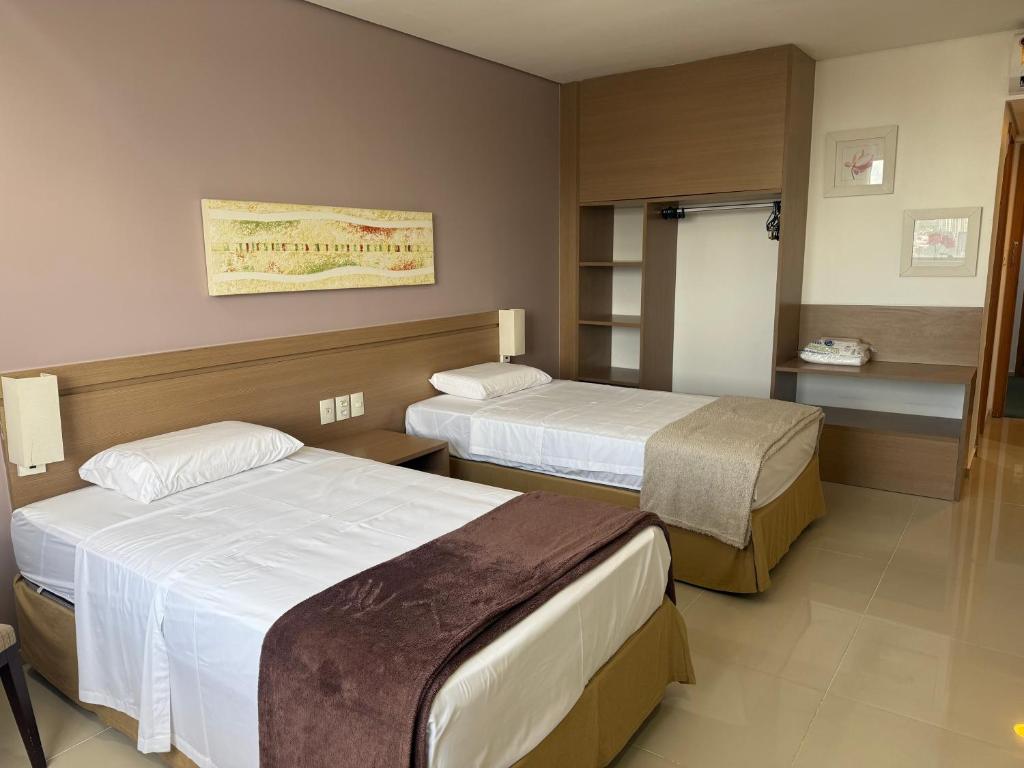 a room with two beds in a hotel room at Flat no Hotel Blue Tree in Manaus
