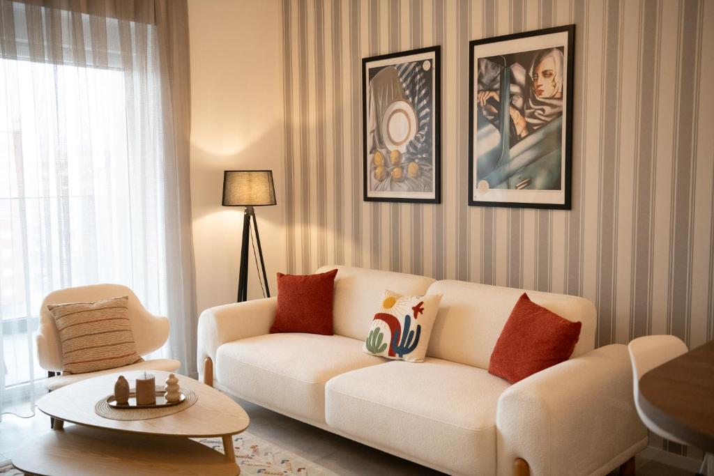 a living room with a white couch and a table at Nova Apartments in Prizren