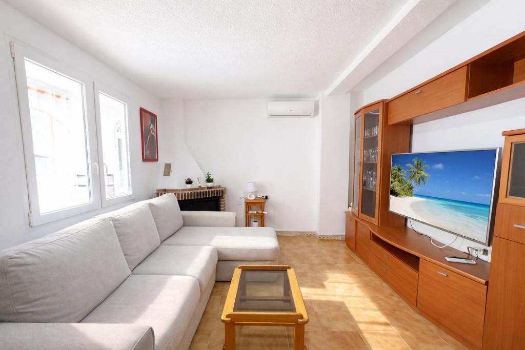 a living room with a white couch and a flat screen tv at Bungalow Oaxaca: Playa de La Mata in Torrevieja