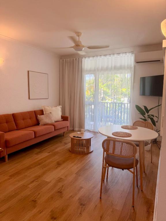 a living room with a couch and a table at Tropic Sands Coastal Escape in Port Douglas