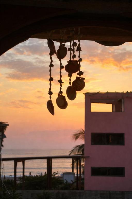 a group of bells hanging from a building at sunset at Oceanfront, AC and Parking, La Punta in Paso Hondo