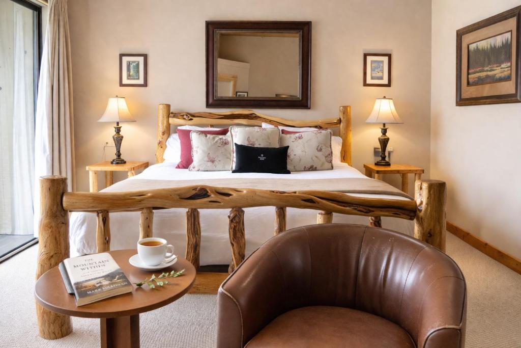 a bedroom with a bed with a chair and a table at Lodge Room 002 in Black Butte Ranch