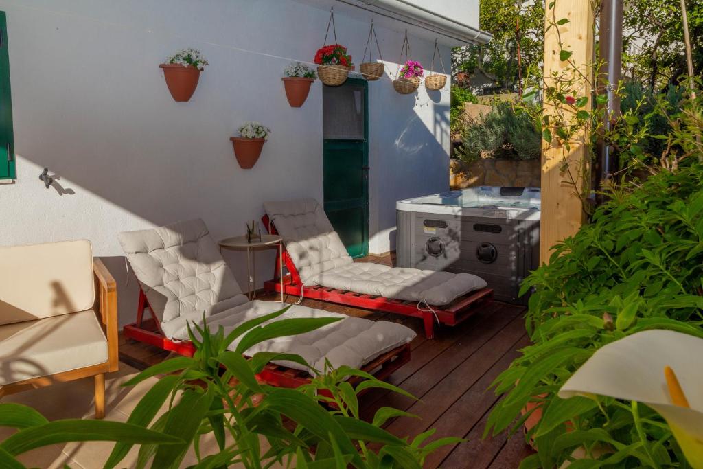 a patio with two chairs and a table at Queen Hvar Luxury Apartment Jacuzzi & Bikes in Hvar