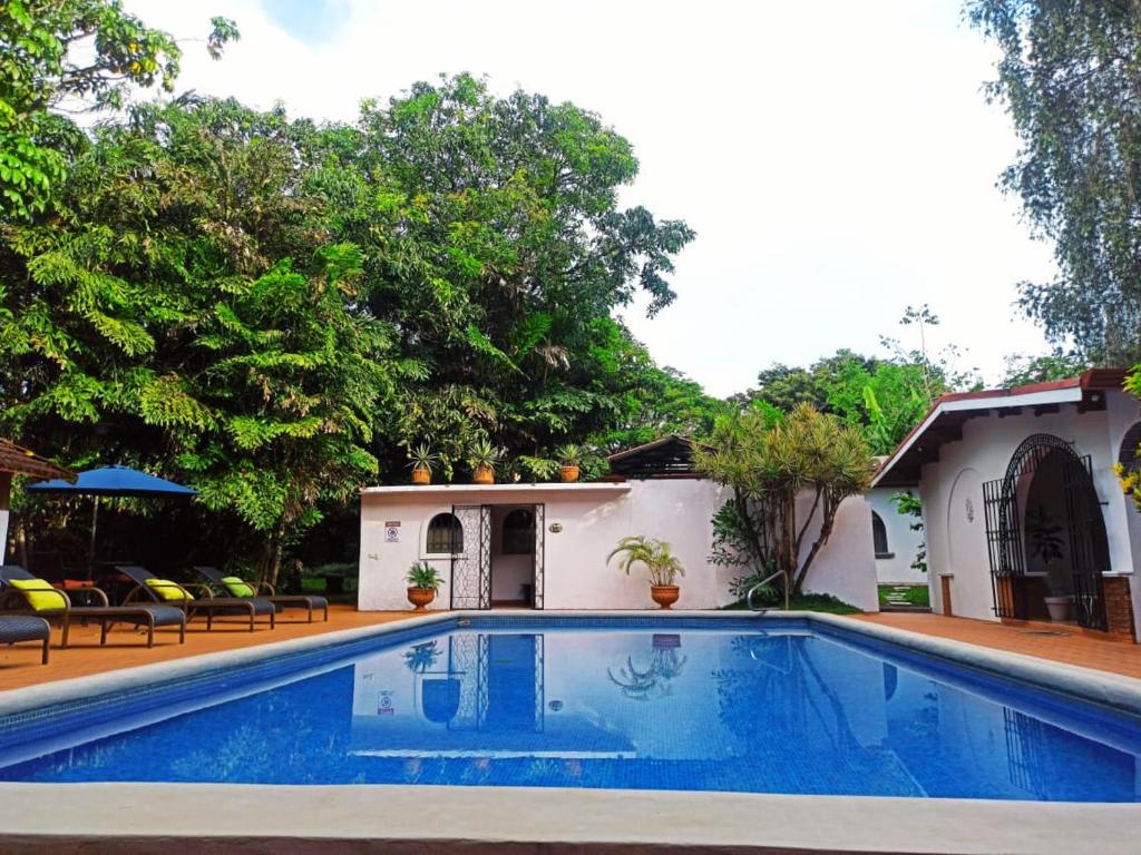 a swimming pool in front of a house at Hacienda Escondida 10min to Airport in Alajuela