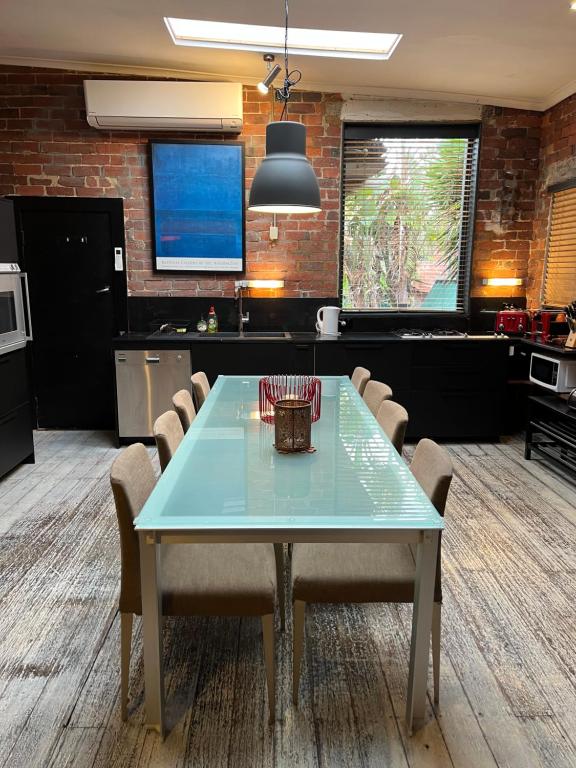 a dining room with a blue table and chairs at beachside loft warehouse artists retreat in Edithvale