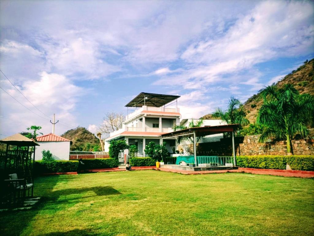 a house with a grass yard in front of it at Anantiva Farms in Rāma