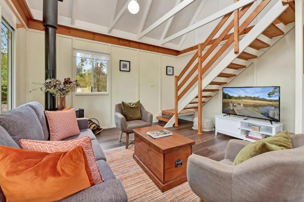 a living room with two chairs and a television at The Meadow Suite in Pokolbin