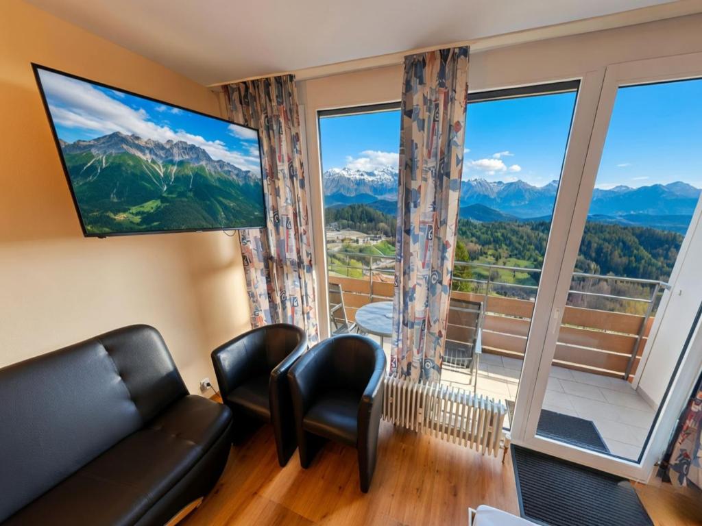 a living room with a couch and chairs and a large window at Studio Sebastian mit Pool und Sauna in Freyung