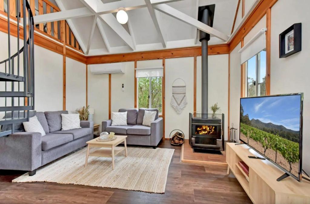 a living room with a tv and a fireplace at The Orchard Suite in Pokolbin