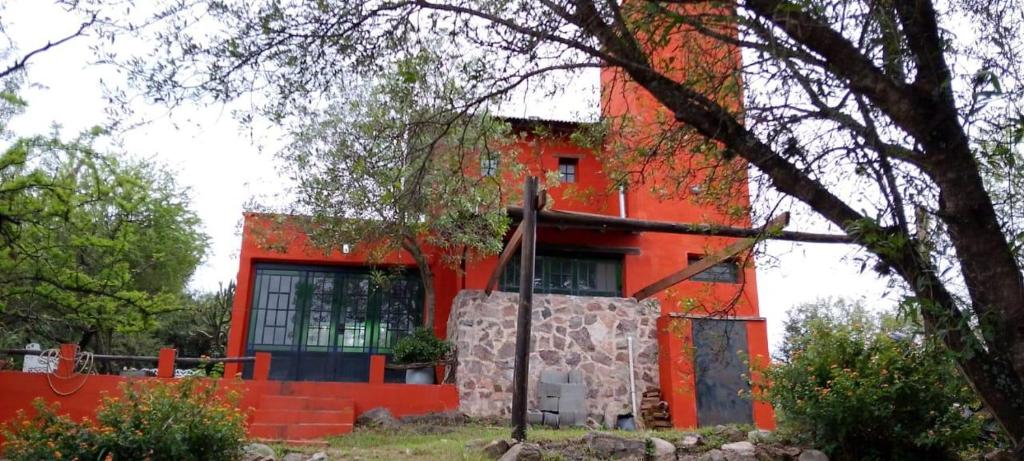 a red building with a large window on the side of it at Casita Naranja in La Calera