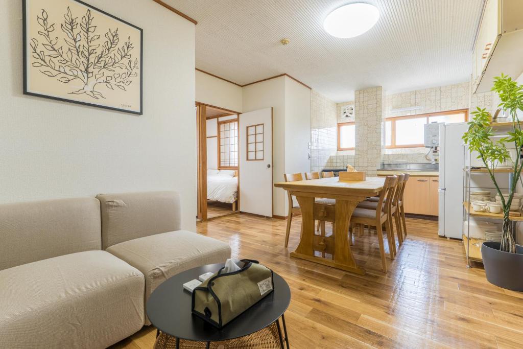 a living room with a couch and a table at オオジンマチ ハイツ303 in Takayama