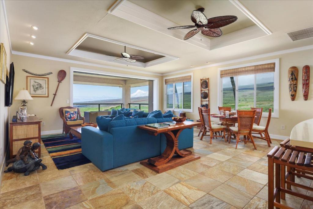 a living room with a blue couch and a table at Beautiful Ocean Villa in Kawela