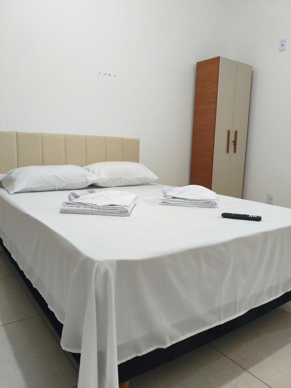 a large white bed with two towels on it at 950 metros da UFV apartamento e ao lado da prefeitura in Viçosa