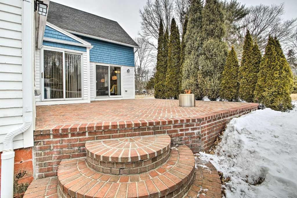 a brick patio with a bench in front of a house at Relaxing Getaway Near Everything in Kennebunk
