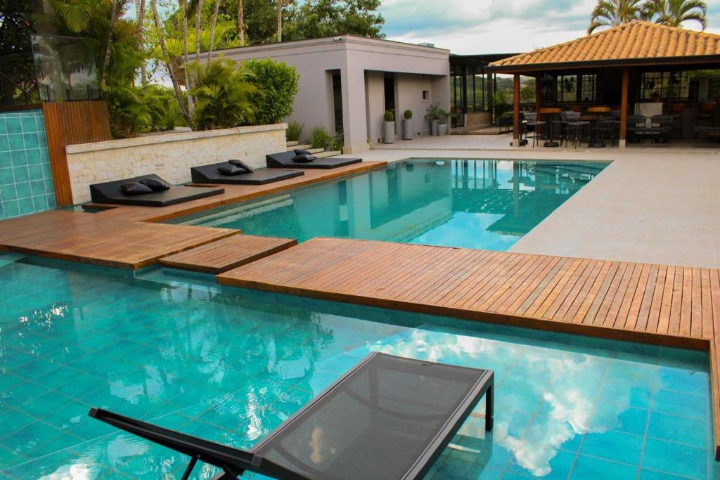 a pool with a wooden deck and a swimming pool at Pousada Villorba in Socorro