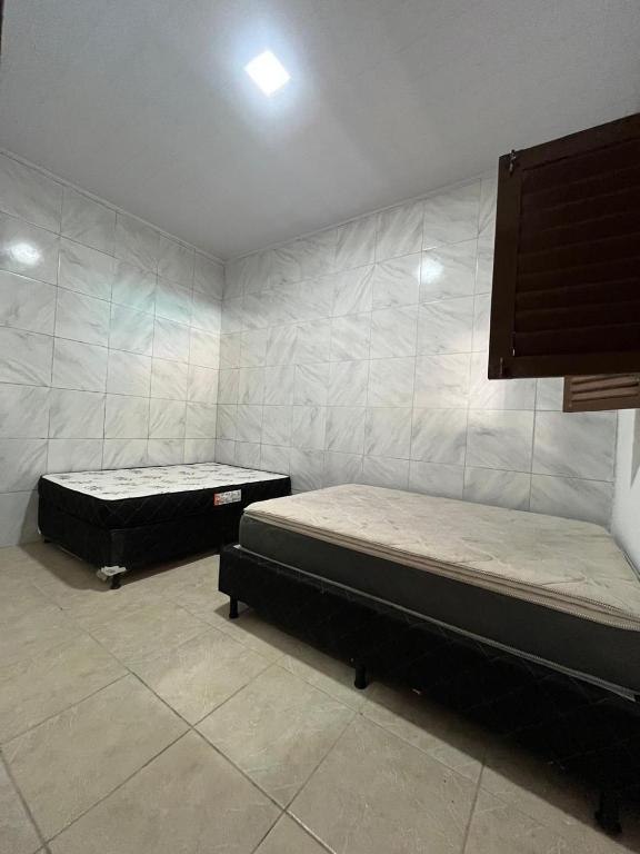 two beds sitting in a room with at Casa de praia conde in Conde