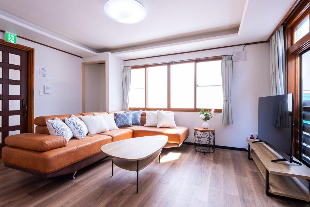 a living room with a couch and a tv at Villa Blanca Yoichi in Yoichi