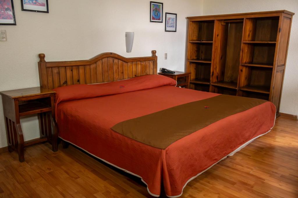 a bedroom with a large bed with a wooden headboard at Hotel San Angel in Puebla