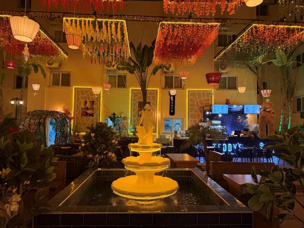 a large yellow fountain in the middle of a room at GoldHome Apart Otel in Famagusta