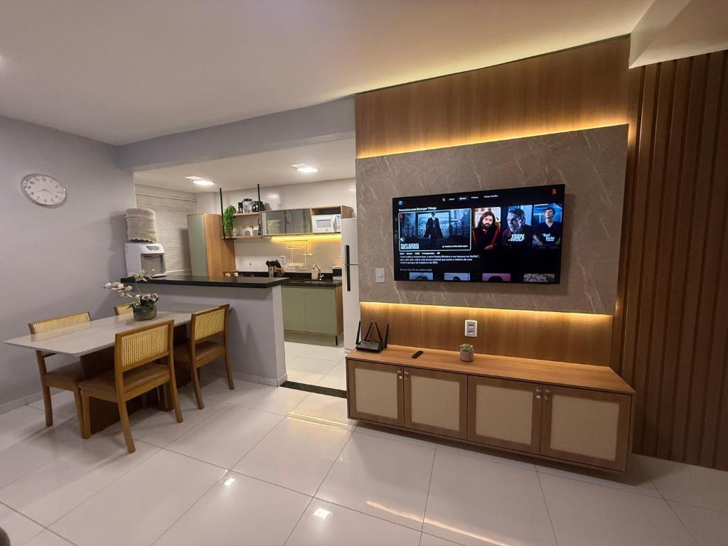 a kitchen and a living room with a tv on a wall at Lençois Confort in Barreirinhas