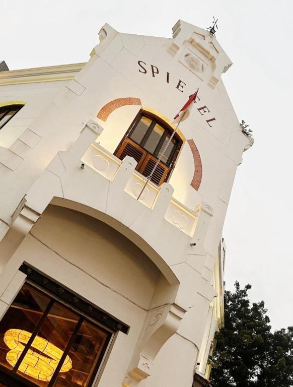a white building with a clock on it at Spiegel Home Studio in Semarang