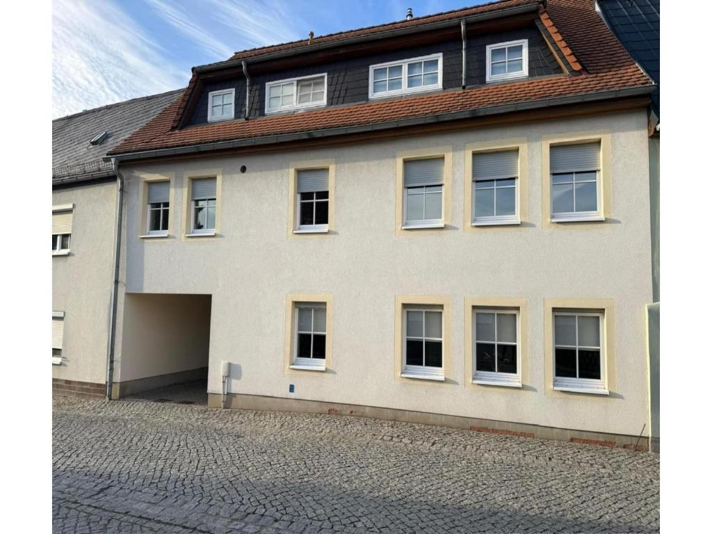 a large white house with a lot of windows at behagliche Ferienwohnung in Elstra in Elstra