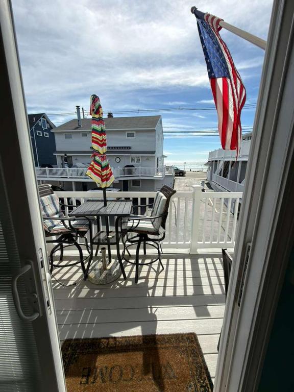 a table and chairs on a deck with an american flag at Oceanview Loft York in York