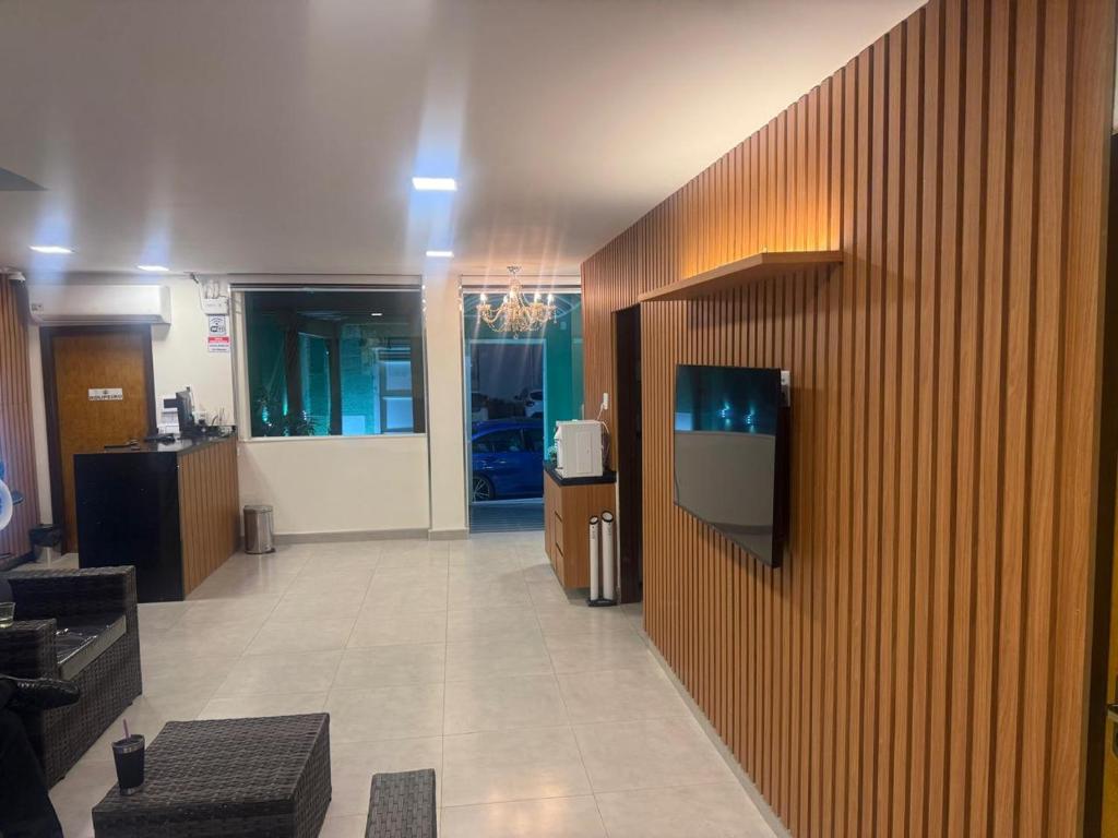 a lobby with a tv on a wooden wall at Hotel Paraiso Go in Valparaíso de Goiás